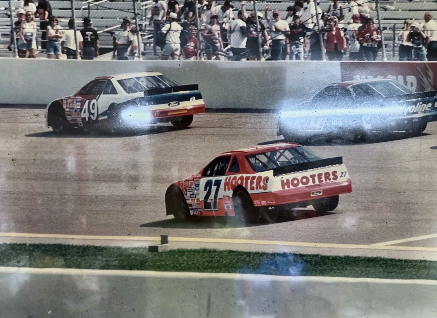 Historical photograph of the number 49, number 27, and another race car on the track