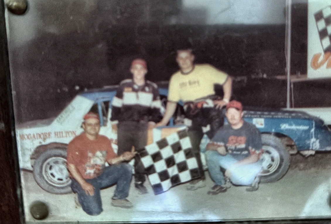 Historical victory photograph of a race team with a checkered flag
